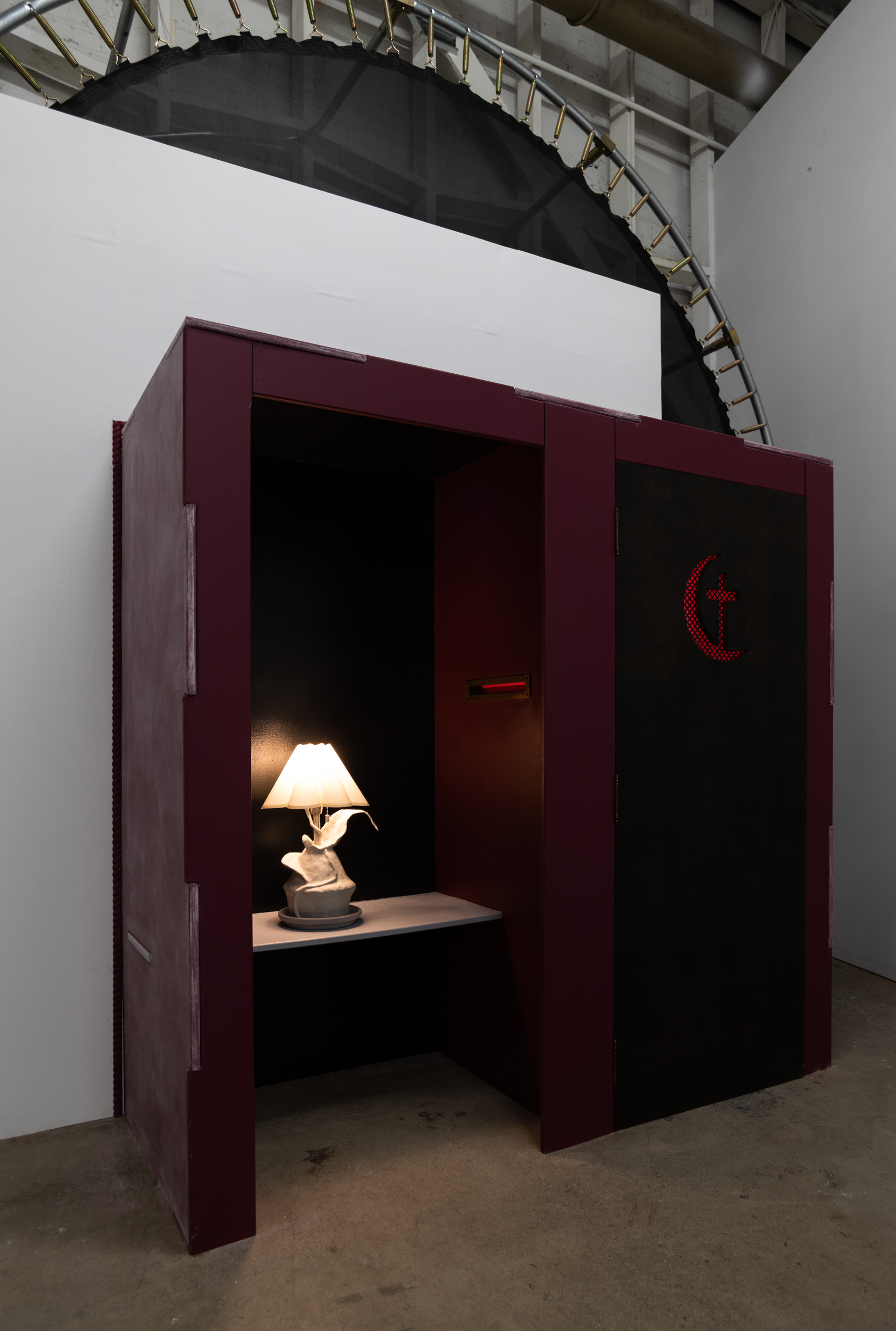 This photograph is slightly closer up than the previous wide installation shot and is taken diagonally rather than frontally. Inside of the confessor's booth there is a vintage brass mail slot which connects the two portions of the booth. 